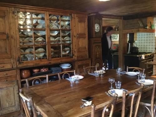 uma sala de jantar com uma mesa e uma pessoa numa cozinha em Chalet le 1791 em La Clusaz