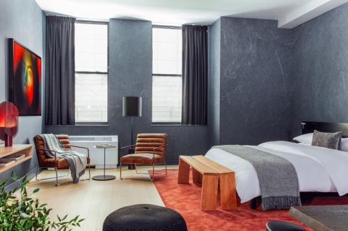 een slaapkamer met een bed en een tafel en stoelen bij Mint House at 70 Pine in New York