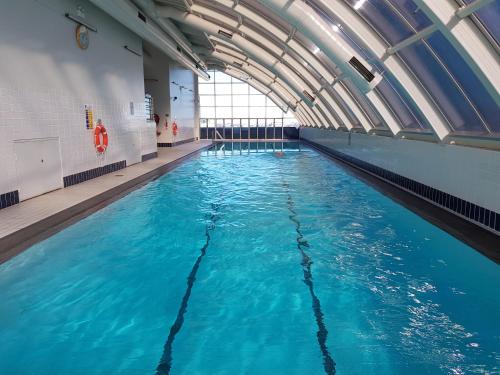 ein großer Pool mit blauem Wasser in einem Gebäude in der Unterkunft Darling Harbour 2 Bedroom Apartment in Sydney