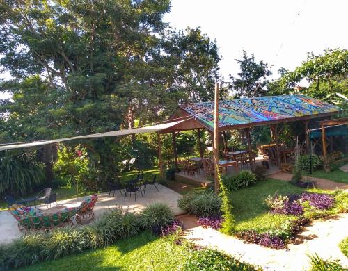 einen Garten mit einem Pavillon mit einem Tisch und Stühlen in der Unterkunft Muti Entebbe in Entebbe