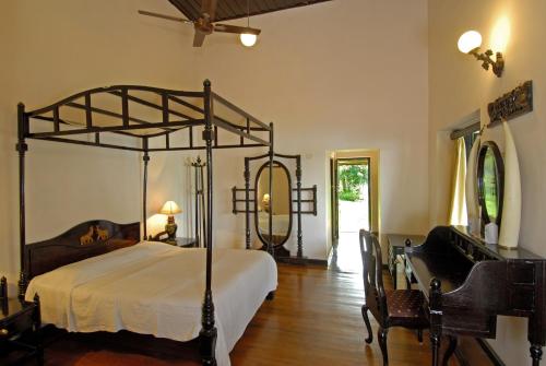 1 dormitorio con cama con dosel, mesa y sillas en Lake Palace, en Thekkady