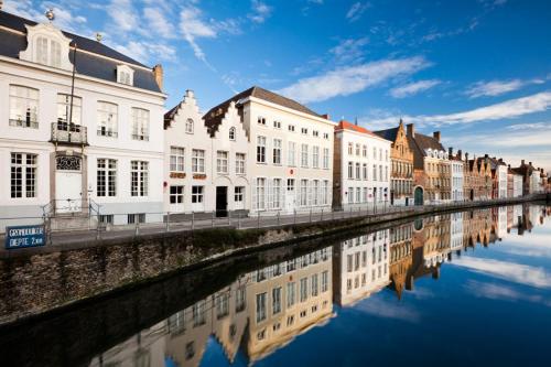 a group of buildings next to a river at Apartment Het Blekershuys in Bruges