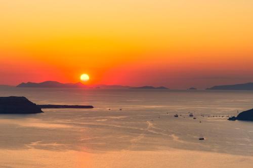 een groep vogels in het water bij zonsondergang bij Barocco Bello Villa in Fira