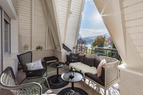 einen Balkon mit einem Sofa, Tischen und Stühlen in der Unterkunft Apartment Vila Pavlovski in Bled