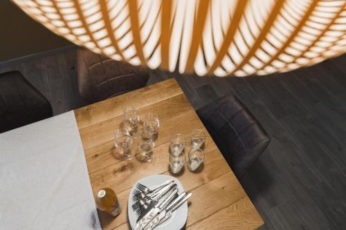 a table with wine glasses and silverware on it at Hissla Riquewihr Le Schlupf & La Perle in Riquewihr