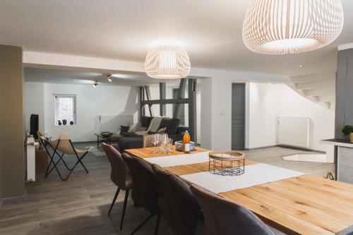 a dining room and living room with a table and chairs at Hissla Riquewihr Le Schlupf & La Perle in Riquewihr