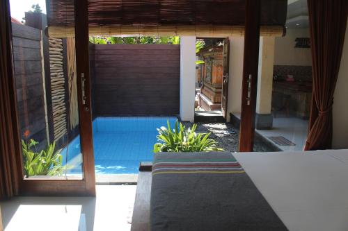 a view of a pool from the entrance of a house at Jukung Villas Kuta in Kuta