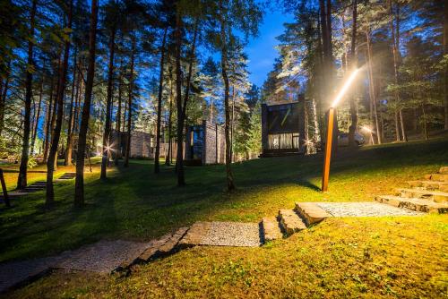 una casetta nel bosco con il sole splendente di TonyResort a Trakai