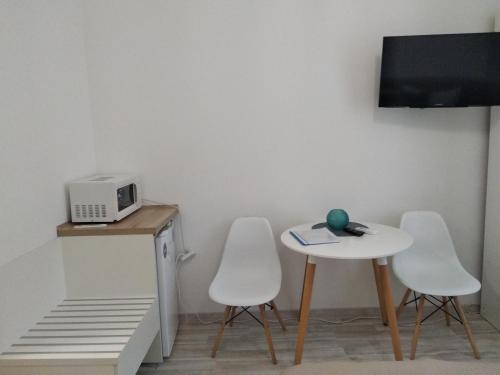 um quarto com uma mesa, 2 cadeiras e um micro-ondas em Kharkov & Apartments in the city center em Carcóvia