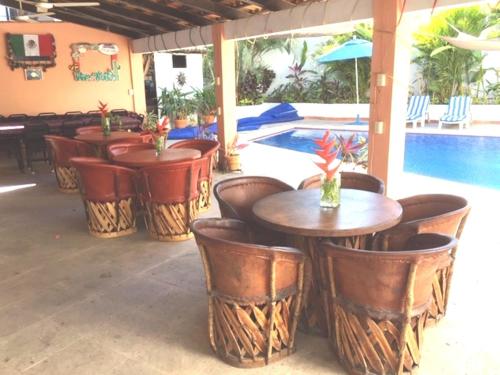 a group of tables and chairs next to a pool at Casa las Flores in Puerto Vallarta