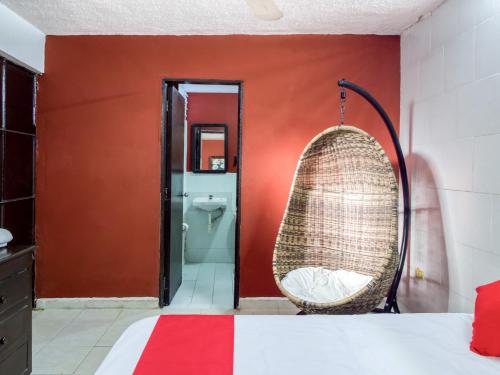 a room with a bed and a wicker swing at Hotel Aventura in Mérida