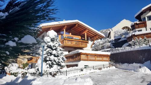 a building with a balcony in the snow at Apartments Dolomie in Ortisei