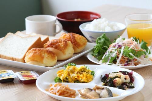 een tafel met drie borden eten erop bij Best Inn Uozu in Uozu