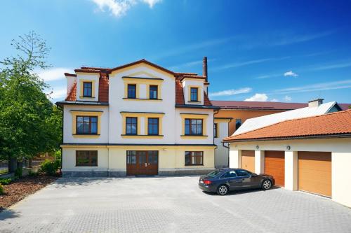 a car parked in a parking lot in front of a house at Vila Encore in Valašské Meziříčí