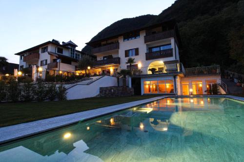 una grande piscina di fronte a una casa di Hotel Römerrast a Caldaro