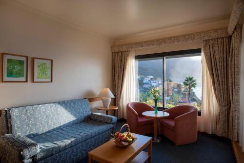 sala de estar con sofá y ventana en Monte Mar Palace Hotel, en Ponta Delgada