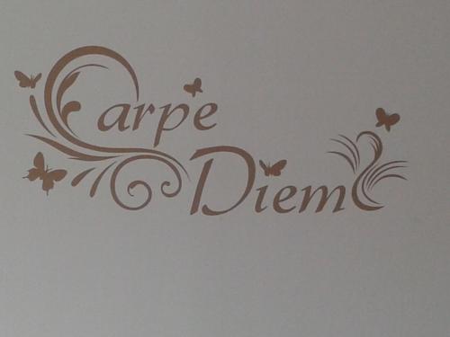 Room "Carpe Diem" في Zele: جدار فيه فراشات وكلمة تفاح يحلم