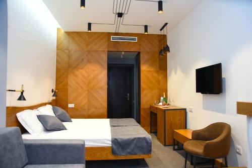 una camera con letto, sedia e televisore di R&R Hotel a Yerevan