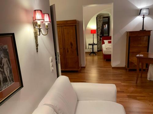 a living room with a white couch and a bedroom at Hotel Deutscher Kaiser in Nürnberg