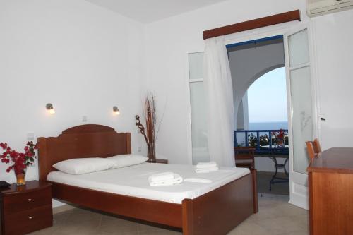 - une chambre avec un lit et un balcon dans l'établissement Aiolos Hotel, à Iraklia