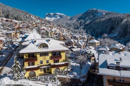 uma aldeia coberta de neve com montanhas ao fundo em Residence Villa Stella em Ortisei