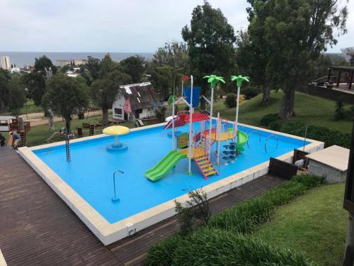 una grande piscina con scivolo e parco giochi di Complejo Laderas del Cerro a Piriápolis