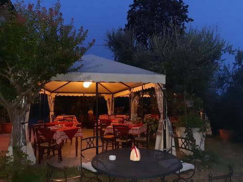 uma tenda com mesas e cadeiras num jardim à noite em Agriturismo Borgo La Casetta em San Baronto