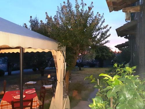 uma mesa e cadeiras debaixo de uma tenda num quintal em Agriturismo Borgo La Casetta em San Baronto