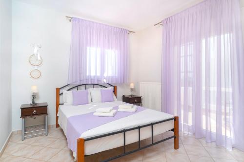 1 dormitorio con 1 cama grande y cortinas moradas en Villa Golden Nest, en Limenaria