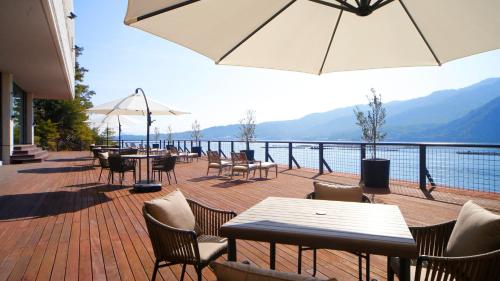 d'une terrasse avec tables et chaises et vue sur l'eau. dans l'établissement Aki Grand Hotel & Spa, à Miyajima