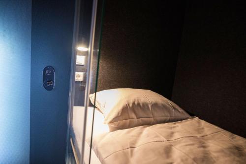 a bed in a room with a glass wall at BoxHotel Hannover in Hannover