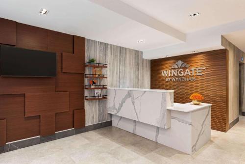 een lobby met een muur met een bord erop bij Wingate by Wyndham New York Midtown South/5th Ave in New York