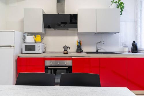 a kitchen with red cabinets and a microwave at San Marco 4893 in Venice