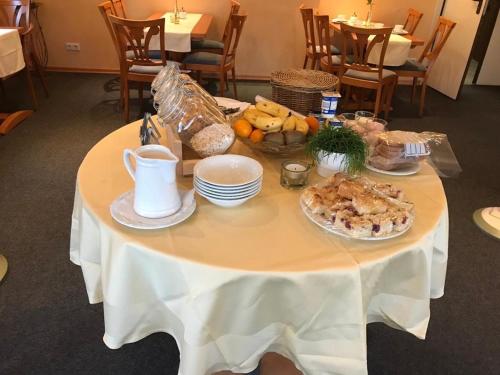 een witte tafel met een bord eten erop bij Hotel Waldfrieden in Emmelshausen