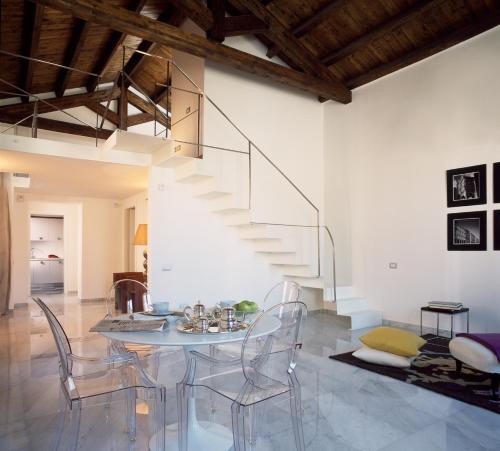 uma sala de jantar com uma mesa de vidro e cadeiras em Right House - Characteristic Marina District em Cagliari