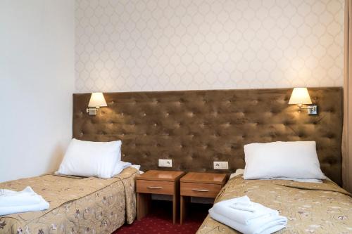 ein Hotelzimmer mit 2 Betten und weißen Kissen in der Unterkunft Hotel Karczówka in Kielce