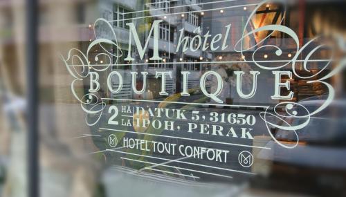 una finestra con un cartello per una boutique di hotel di M Boutique Hotel a Ipoh