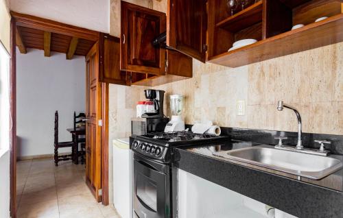 een keuken met een fornuis en een wastafel bij Olas Altas Suites Departamentos in Puerto Vallarta