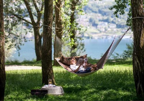 un hombre y una mujer tumbados en una hamaca en Castello del Sole Beach Resort&SPA, en Ascona