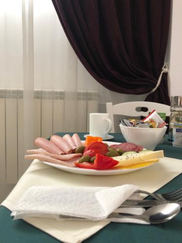 une plaque de viande et de légumes sur une table dans l'établissement London Hotel, à Constanţa