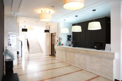 een lobby met een receptie en hanglampen bij Legendary Lisboa Suites in Lissabon