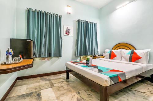 um quarto com uma cama e uma televisão em FabExpress Santhi Inn - Near Promenade Beach em Pondicherry