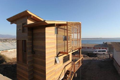 une maison en bois avec un escalier sur son côté dans l'établissement Tongoy Beach Tinyhouse, à Tongoy