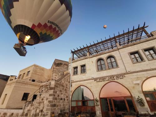 Ein Heißluftballon fliegt über ein Gebäude in der Unterkunft My Story Cave Hotel in Uchisar