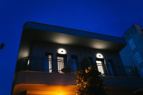 ein Gebäude mit Balkon in der Nacht in der Unterkunft Volos Suites Center in Volos