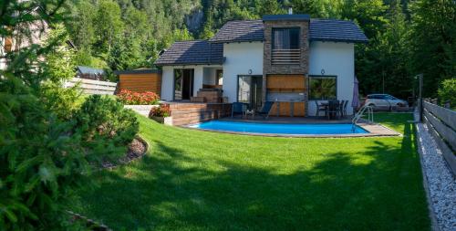 een huis met een zwembad in een tuin bij Hiša Katja-Privat wellness in Kranjska Gora