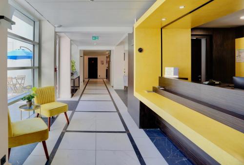 een hal van een ziekenhuis met een gele en witte lobby bij Best Western Hôtel Journel Antibes Juan-les-Pins in Antibes