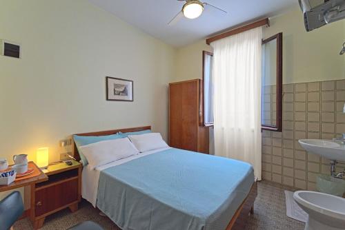 una camera con letto e un bagno con lavandino di Albergo Al Gobbo a Venezia