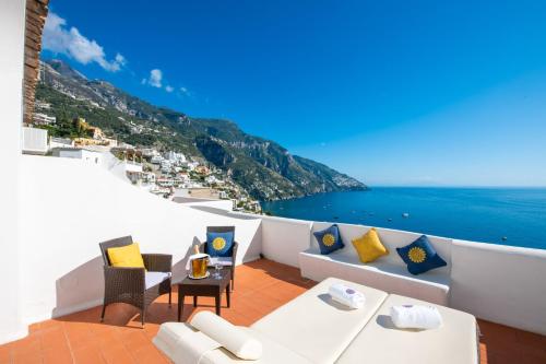 balcone con mobili bianchi e vista sull'oceano. di La Casa di Peppe a Positano