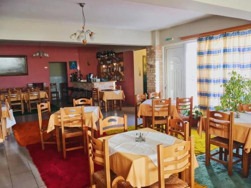 um restaurante com mesas e cadeiras num quarto em Ξενοδοχείο "Ηραία" em Iamatikes Piges